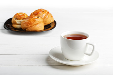 White cup of tea on a white wooden table.