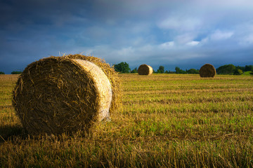 Haystack on a field of stubble. August countryside landscape. Masuria, Poland.