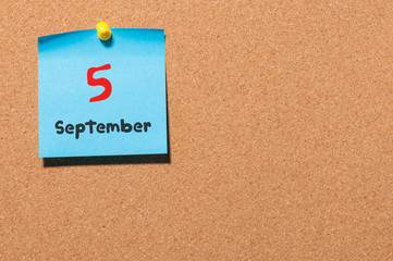September 5th. Day 5 of month, color sticker calendar on notice board. Autumn time. Empty space for...