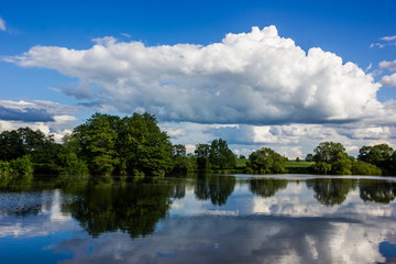 Summer lake with green pasture and blue sky with clouds - Czech Republic, Europe