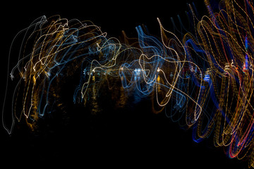 Abstract drawing by light with colored lines cyclic on a black
