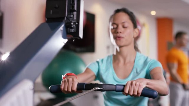  Woman working out on rowing machine at the gym