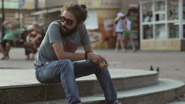 Man cut and eating apple in the park