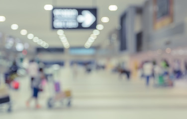 Blurred passengers in airport arrival terminal background