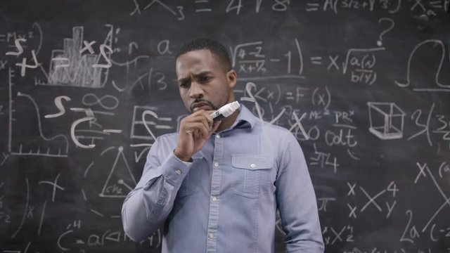  Happy little scientist with fake mustache writing math formulas on blackboard