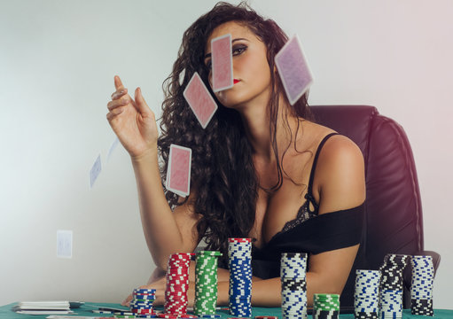 Provocative girl throwing cards in air, poker chips on table