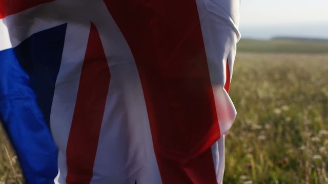 Attractive woman wears a union jack flag as she looks towards horizon