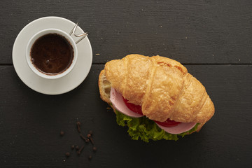 sandwich on croissant and coffee top view
