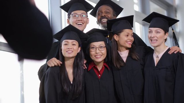  Happy group of mature students on graduation day pose for photo