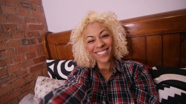  Happy young woman in bed at home, posing and pulling faces to camera