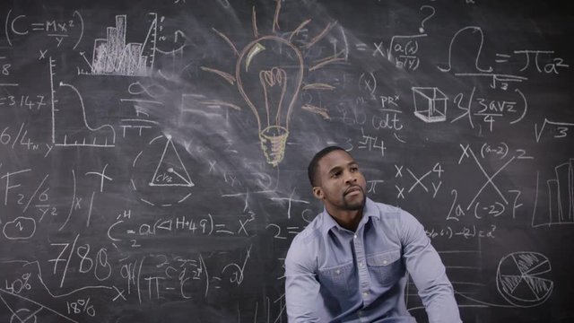  Happy little scientist with fake mustache writing math formulas on blackboard