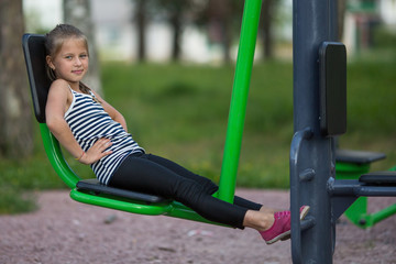 Fototapeta na wymiar Ten-year-old girl is engaged in sports equipment outdoor.