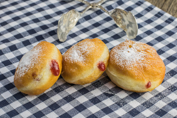 Three berliners (doughnut) with strawberry jam