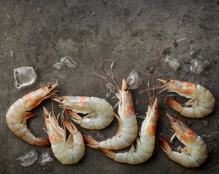 fresh raw prawns on dark gray background