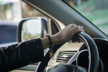 Naklejka premium Young confident businesswoman driving car
