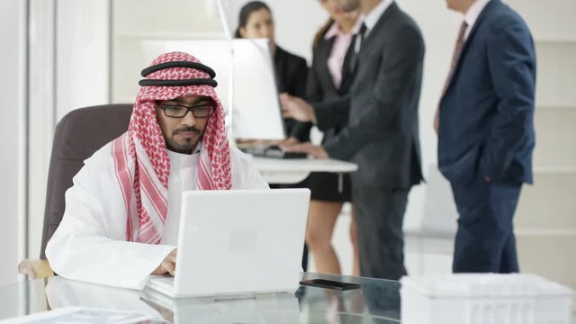  Portrait smiling Arab businessman with business team in background