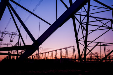 The silhouette of the evening electricity transmission pylon