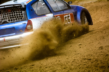 Autocross on a dusty road. Car in competition up the road on a dirt road