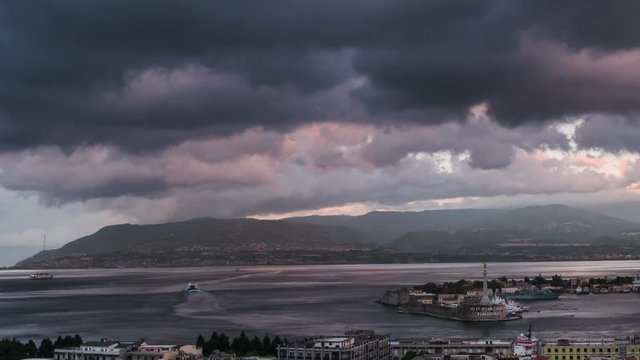 Day to night transition timelapse of the Port of Messina in Sicily Italy. Moving clouds and sunset light with night illumination.