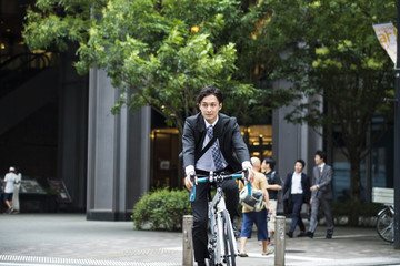 Fototapeta na wymiar Cool businessman is riding the road bike