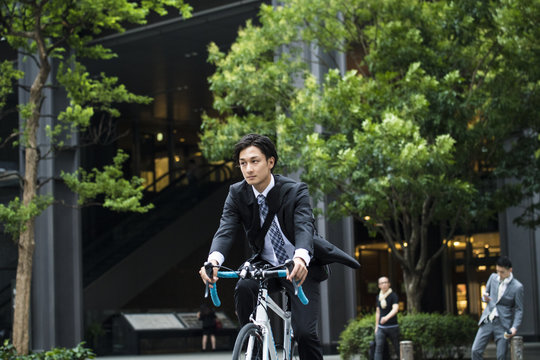 Young and cool businessman is riding the road bike