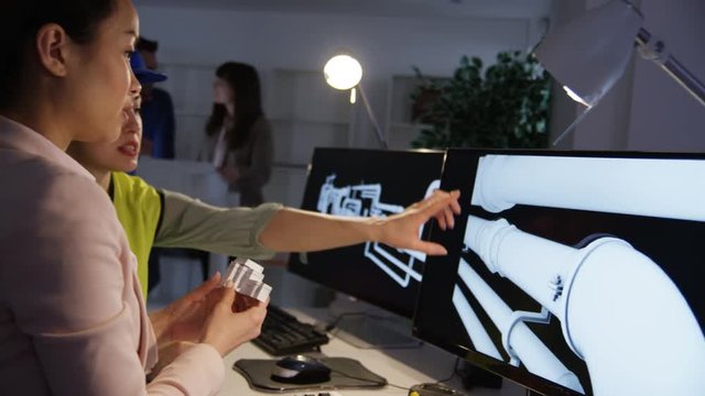  Engineers working on a project using computer software & discussing ideas