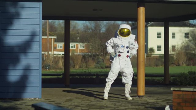  Funny astronaut doing stretches and warm up exercises in street