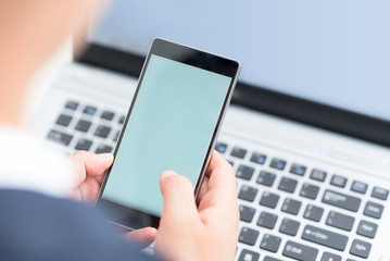 Businessman using smart phone and laptop.