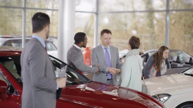  Portrait of smiling salesman working in car dealership
