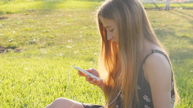 Young woman on grass with phone