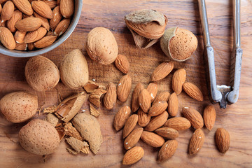 Almonds and an old nutcracker on a wooden table