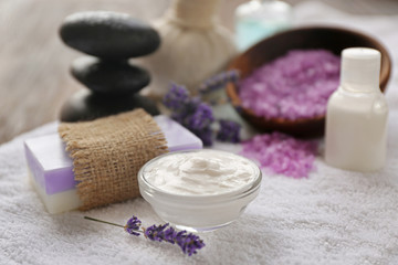 Spa composition with lavender, towel and cream on wooden background