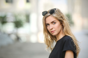 Beautiful stylish girl on blurred street background