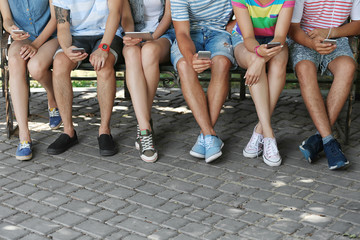 Fototapeta na wymiar Teenagers with gadgets on street