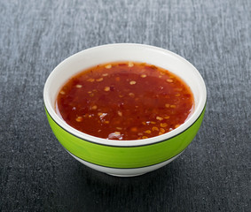 bowl of chili sauce on wood background