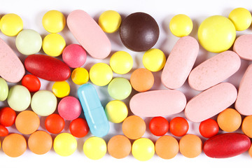 Colorful medical pills and capsules on white background, health care concept