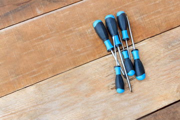 Top view the Phillips screwdriver and flat screwdriver on wood.