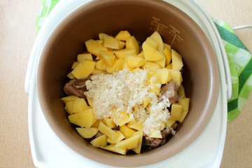 Cooking soup multivarka - rice soup with chunks of meat.