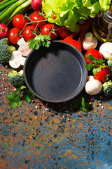 empty cast iron skillet and fresh organic vegetables 