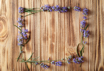 Frame of lavender flowers on wooden background