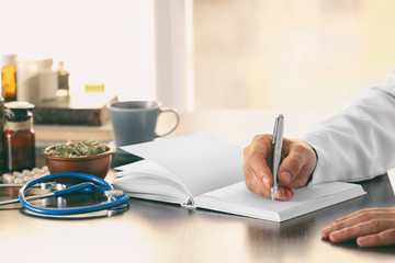 Male doctor with medical recipe book. Herbal medicine concept