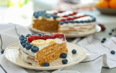 Slice of patriotic American flag cake with berries and bananas on table
