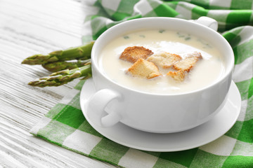 Asparagus soup with crackers on table