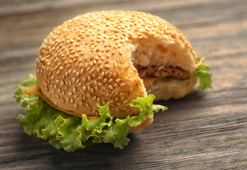 Bitten hamburger on wooden background