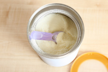 Baby milk formula in can on wooden background