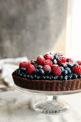 Delicious chocolate tart with berries on a tablecloth