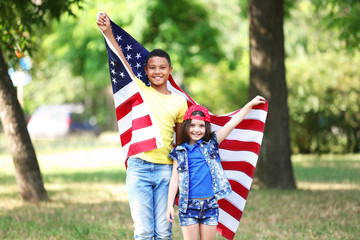 Boy and girl holding American flag in park
