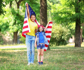 Boy and girl holding American flag in park