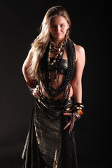 Fototapeta premium young girl in beads and bracelets on black background