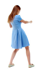 back view of standing girl pulling a rope from the top or cling to something. girl  watching. Rear view people collection.  backside view of person.  Isolated over white background. Skinny girl in a